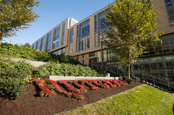 Flowers forming Rutgers lays accross field next to the Academic Building