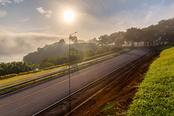 Turn in the road with guardrail and vegetation on either side